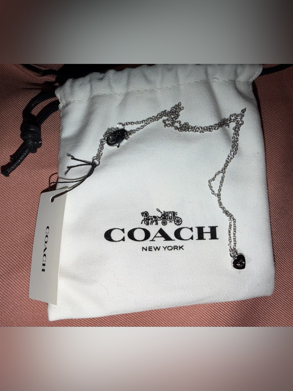 Coach Silver Heart Charm Necklace on White Pouch